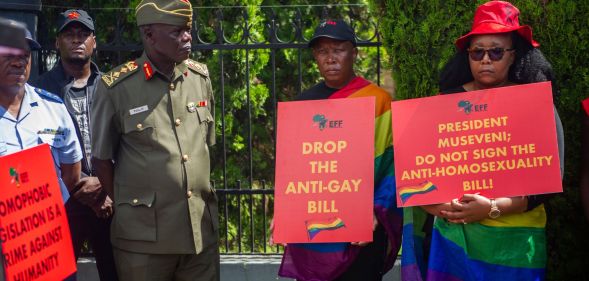 Uganda protestors hold signs urging the president to drop the anti-gay bill.