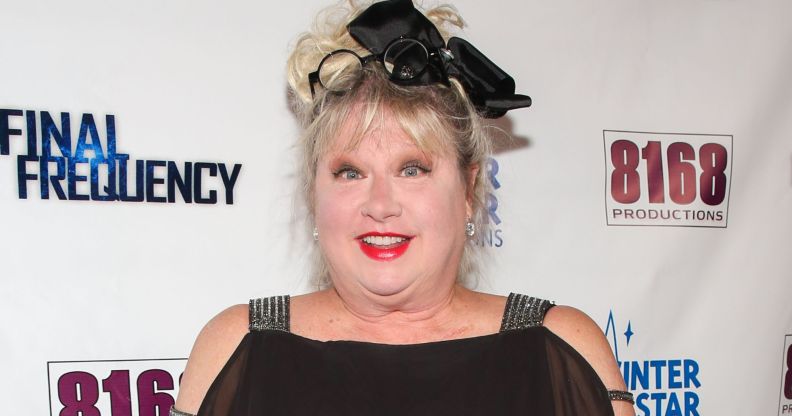 Victoria Jackson gawps at camera wearing black dress and black ribbon in her hair.