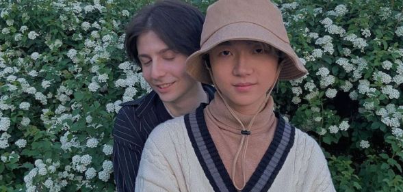 Russia based LGBTQ+ couple Gela and Haoyang hold each other as they pose outside