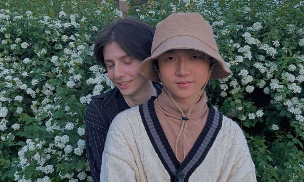 Russia based LGBTQ+ couple Gela and Haoyang hold each other as they pose outside
