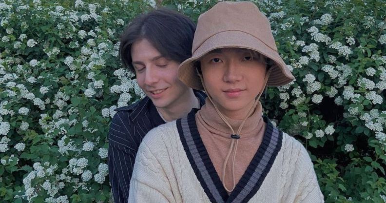 Russia based LGBTQ+ couple Gela and Haoyang hold each other as they pose outside