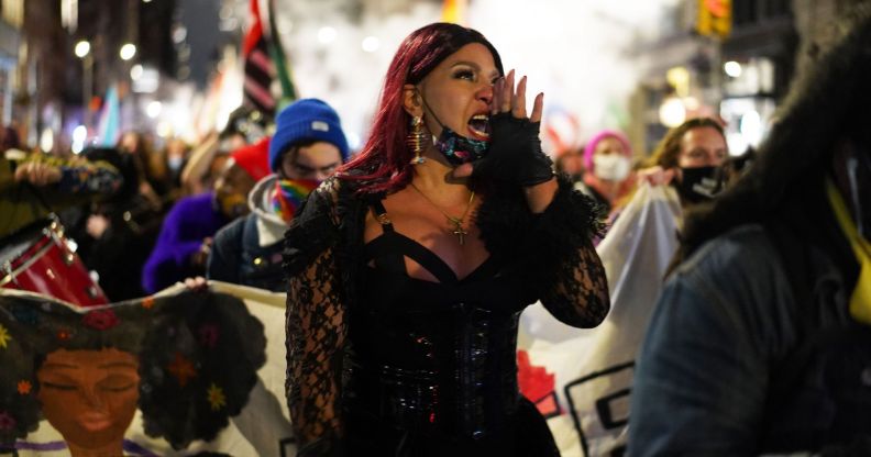 Trans activist Iman Le Caire holds up her hand near her mouth as she speaks during a protest march