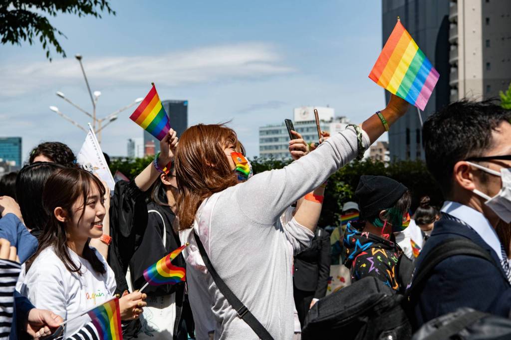 A person waves a rainbow LGBTQ+ flag during a Pride march in Tokyo, Japan