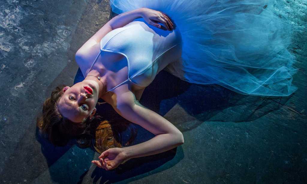 Maggie lying on the ground in a blue tutu