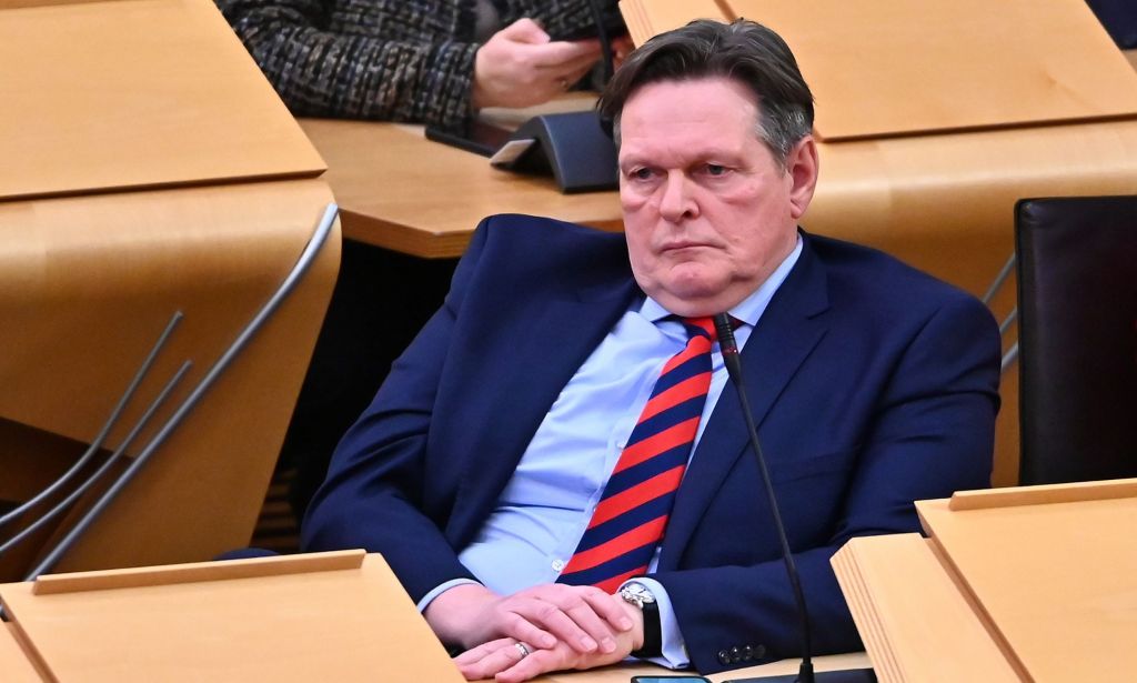 Scottish Tory MSP Stephen Kerr wears a suit and tie as he sits at a desk in Holyrood. He has been an opponent of Scotland's pro-trans Gender Recognition Reform bill