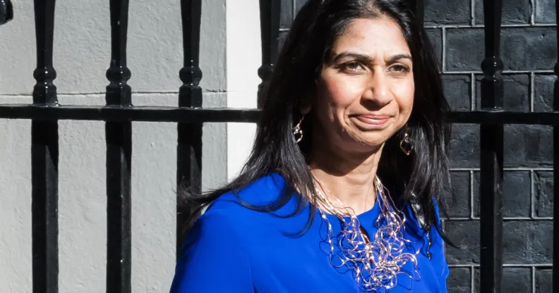 UK home secretary Suella Braverman wears a blue outfit and silver necklace as she steps outside. LGBTQ+ and human rights campaigners have criticised Braverman for her comments about asylum seekers