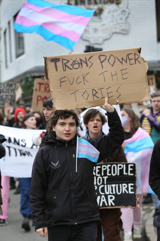 A person holds up a sign reading 'Trans power fuck the Tories' amid a trans rights protest