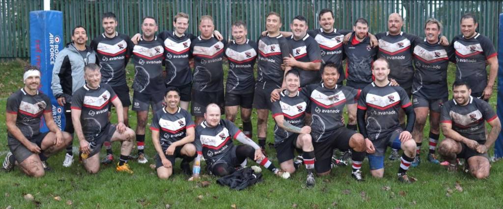 A group photo of the Newcastle Ravens rugby team on the pitch with trans player Jordan Blackwood smiling alongside the other players