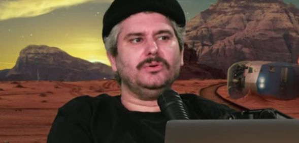 H3 Podcast host Ethan Klein infront of a green screen.