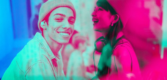 Thisis an image of two people. On the left there is a man and he is wearing a beanie and smiling to the camera. There is a yellow tint over him. On the other side there is a young woman.She is also wearing a beanie and there is a pink tint overlay.