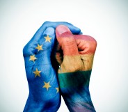 closeup of the hands of a man put together patterned with the flag of the european union and the rainbow flag