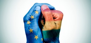 closeup of the hands of a man put together patterned with the flag of the european union and the rainbow flag