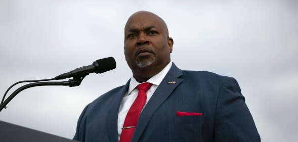 North Carolina lieutenant governor Mark Robinson speaks at a podium wearing a blue suit and red tie