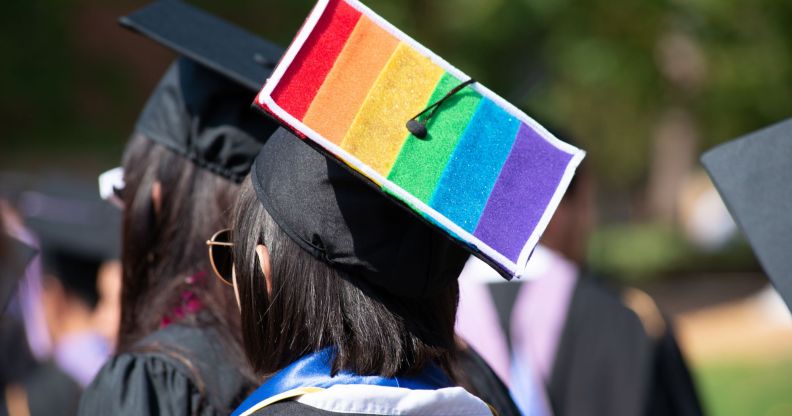 A picture of a person during graduation with a rainbow flag on their cap.