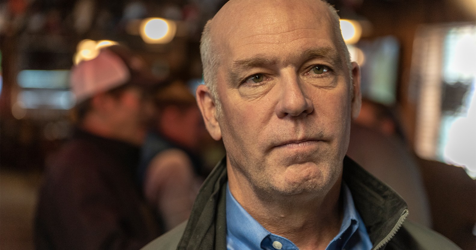 Montana governor Greg Gianforte wearing a jacket in a bar.