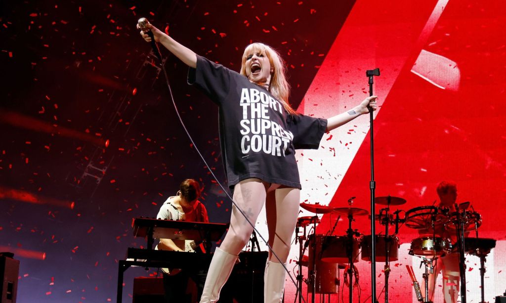 Hayley Williams performing in a black t-shirt with the words 'Abort the Supreme Court' written on it.