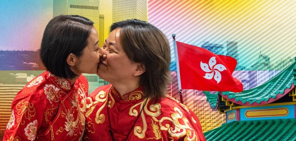 Two women kiss in front of a Hong Kong flag