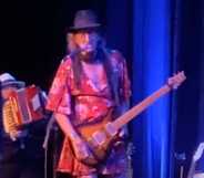 James McMurty performing on stage in a dress