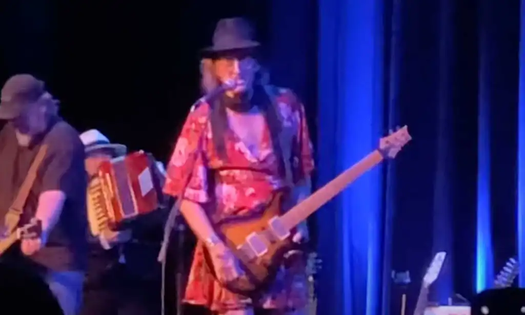 James McMurty performing on stage in a dress