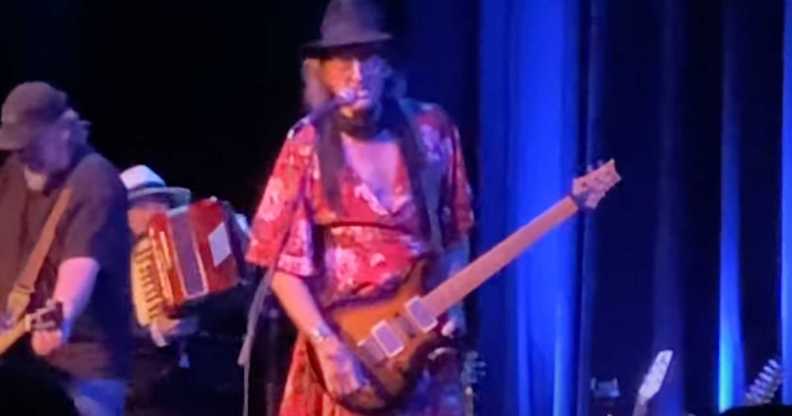 James McMurty performing on stage in a dress