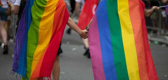 Two children wearing pride flags