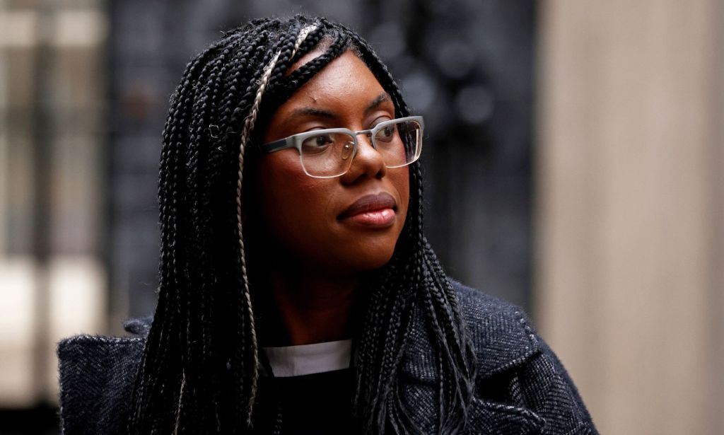 Kemi Badenoch, wearing a grey jacket, turns her head to the left while walking away from Number 10.
