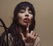 Sweden's Eurovision Song Contest 2023 winner Loreen wearing a cream top and placing a finger over her lips in a promotional photo for her Tattoo Uk and Europe Tour