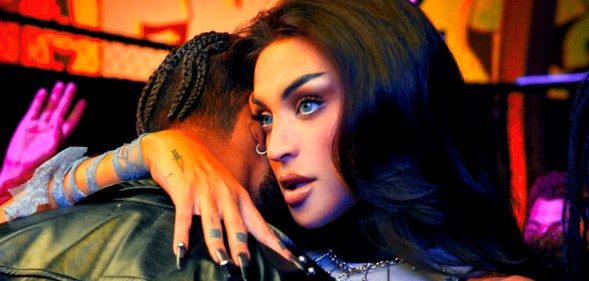 Pabllo Vittar with her arm around a man in a promotional image for the Noitada World Tour