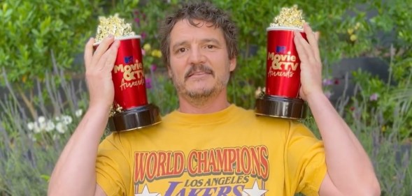 Pedro Pascal holds up two popcorn-shaped awards for the MTV Movie and TV Awards