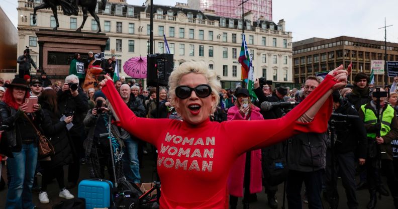 Anti-trans campaigner Posie Parker stands at a rally wearing a top reading "woman, woman, woman"