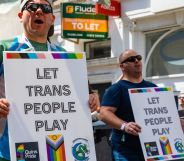 Groups of protestors hold signs reading "let trans people play" during a Pride event.