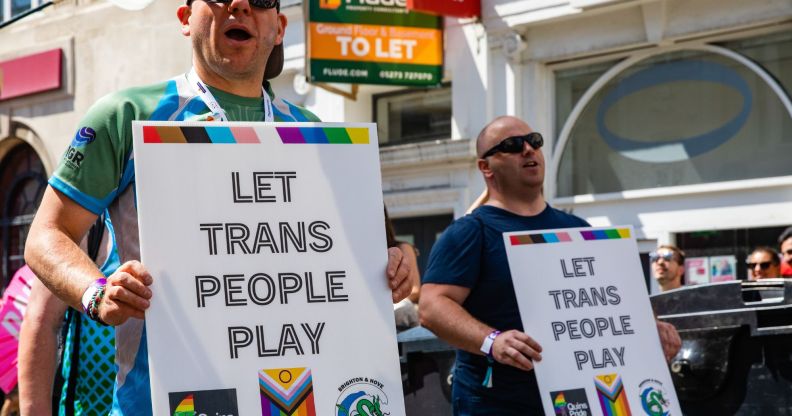 Groups of protestors hold signs reading "let trans people play" during a Pride event.