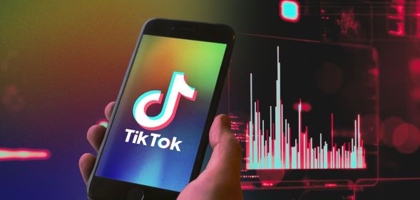 Hand holds phone with TikTok logo on the screen