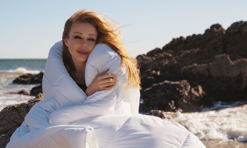 Ukraine singer Tina Karol wrapped in a duvet on a beach.