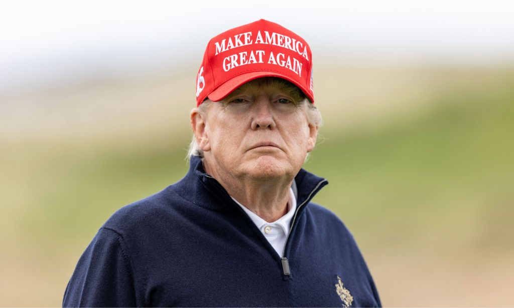 Former President Donald Trump, who is running as a 2024 Republican presidential candidate, wears a white shirt, blue jacket and red hate with his slogan 'Make American Great Again' on it