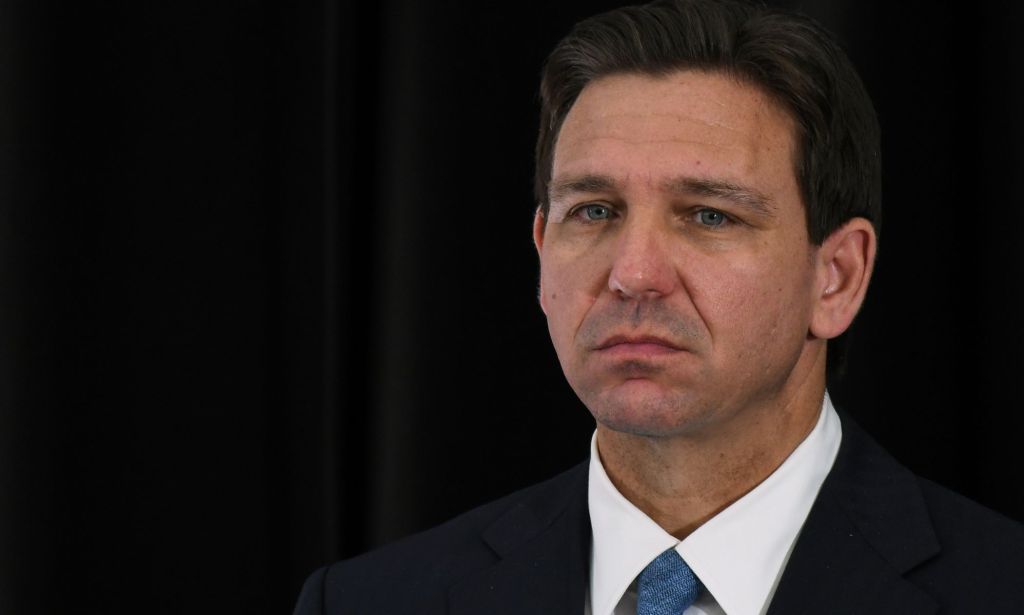 Florida governor Ron DeSantis – who has supported bills that would ban gender-affirming healthcare in the state – wears a white shirt, blue tie and dark jacket as he stares out into the distance