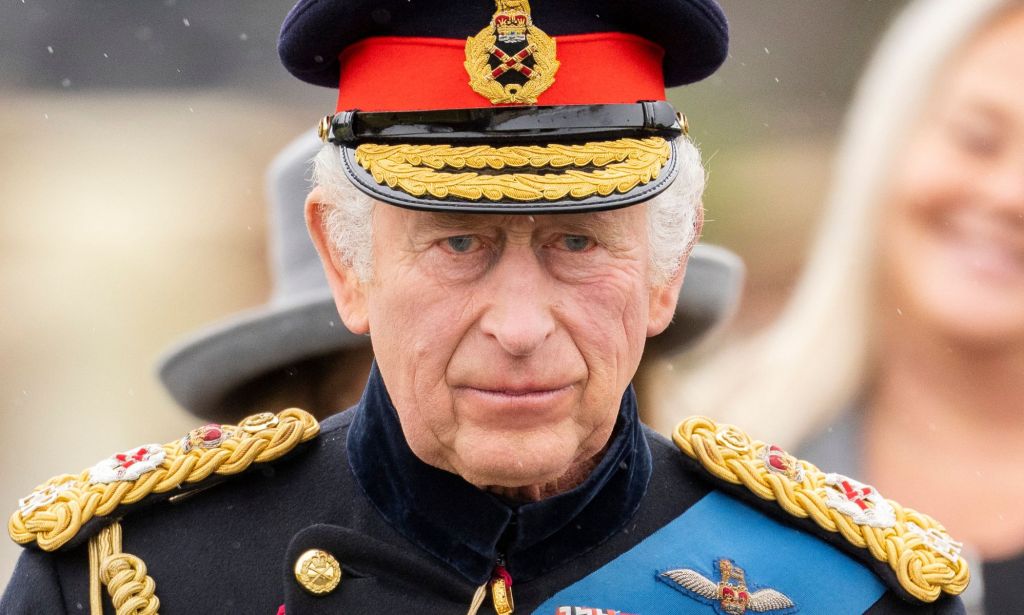 King Charles III wears military dress as he stands amid a crowd preparing for his coronation ceremony