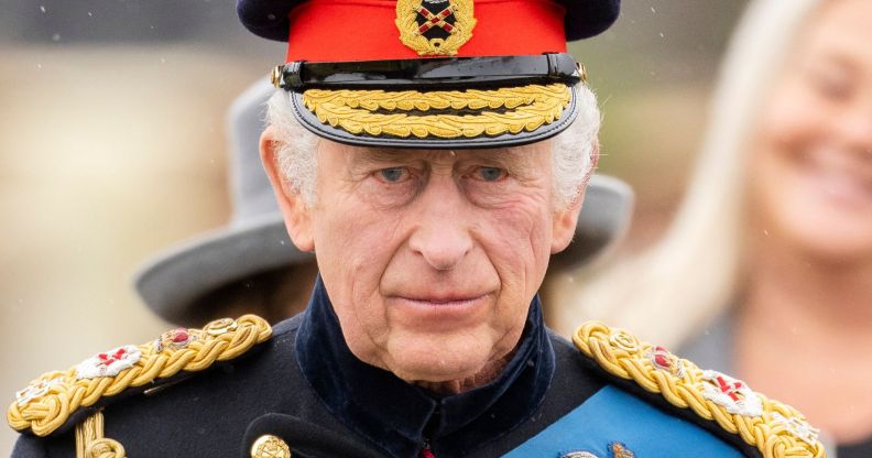 King Charles III wears military dress as he stands amid a crowd preparing for his coronation ceremony