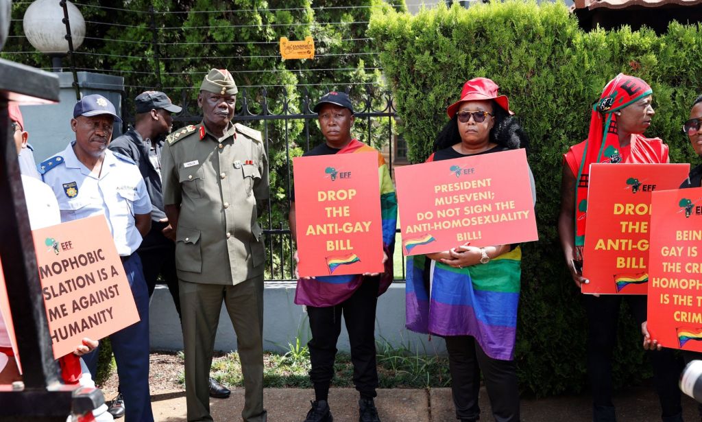 LGBTQ+ and human rights advocates hold up signs denouncing Uganda's Anti-Homosexuality Act during a protest