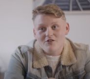 Trans teen Kai wears a white shirt and tan coloured jacket as he is interviewed for a film project by Fox Fisher and My Genderation