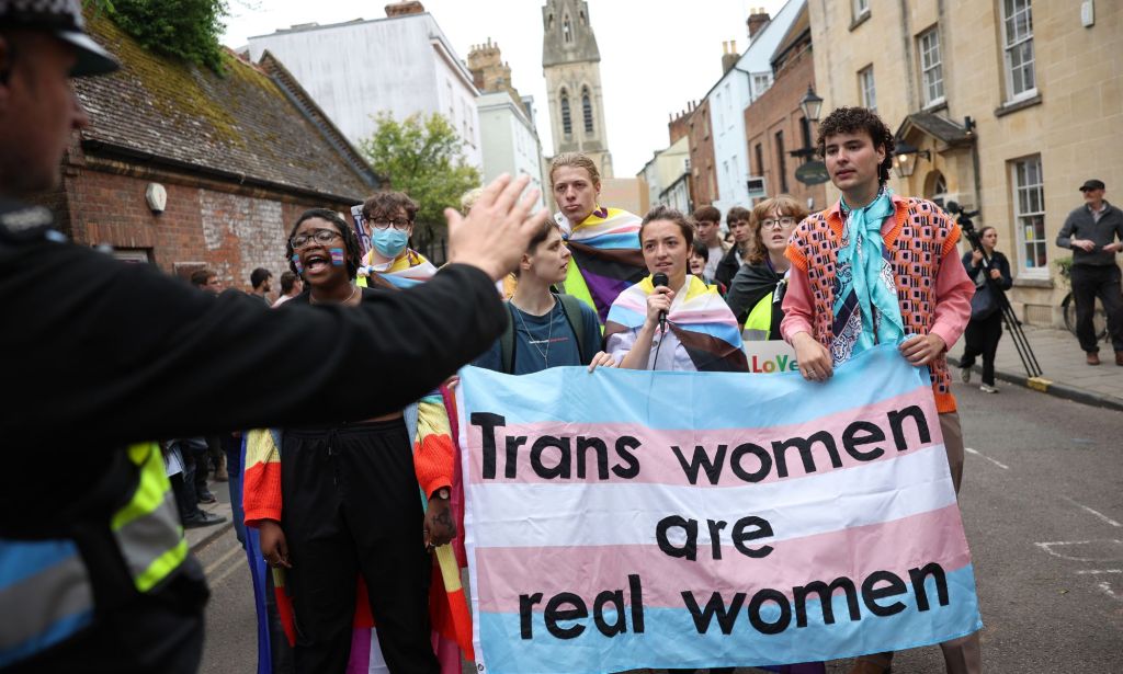 Trans rights advocates hold up a sign reading 'trans women are real women' outside the Oxford Union where Kathleen Stock was set to have a talk