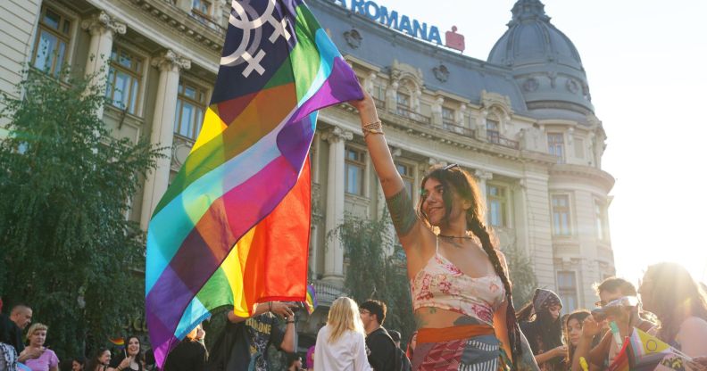 A person holds a Pride flag at Bucharest Pride.