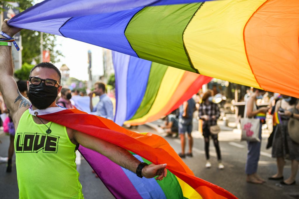 A participant poses with a rainbow flag during the Pride Parade in Bucharest on August 14, 2021.