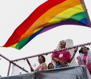 People hold up a rainbow LGBTQ+ Pride flag during a parade in South Korea