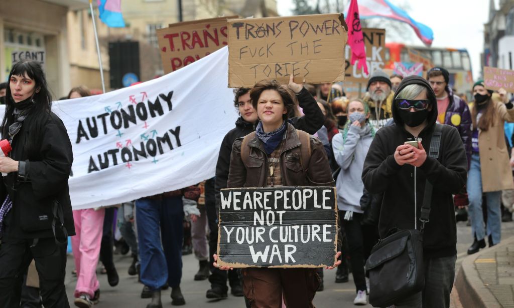 A person holds up a sign reading 'we are people not your culture war' during a trans rights protest