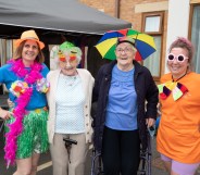 Four people wear rainbow-coloured items to celebrate Silver Pride at Fairway View care home in Nottingham