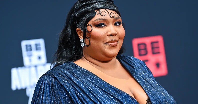 Lizzo wears a blue outfit as she poses for a photo at an event