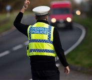 A Dyfed-Powys police officer stands by a nearby road.