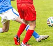 Two players lunging for a football
