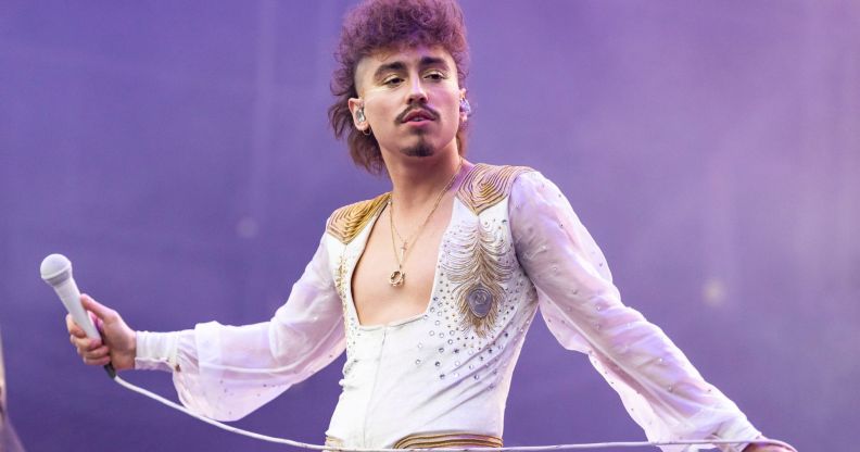 Greta Van Fleet's Josh Kiszka performs on stage, holding a microphone.